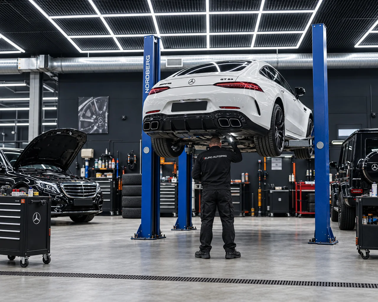 Мастер осматривает белый Mercedes-AMG на подъёмнике